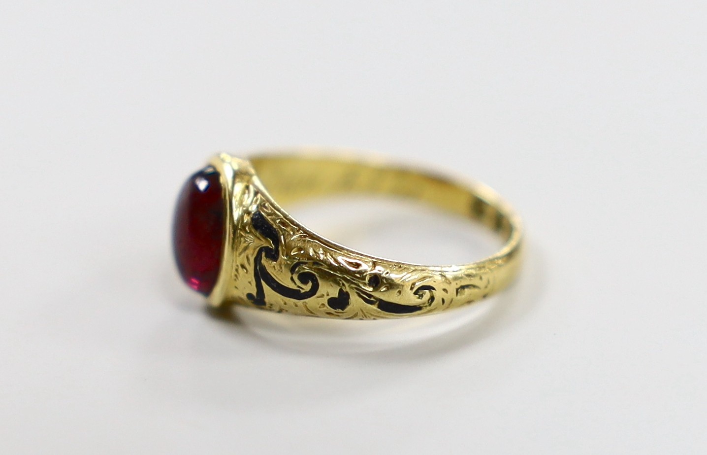 A Victorian 18ct gold, cabochon garnet and black enamel set memorial ring, the shank interior inscribed 'J W Scott obt. 26th Jan, 1851 at 41', size J, gross weight 2.8 grams.